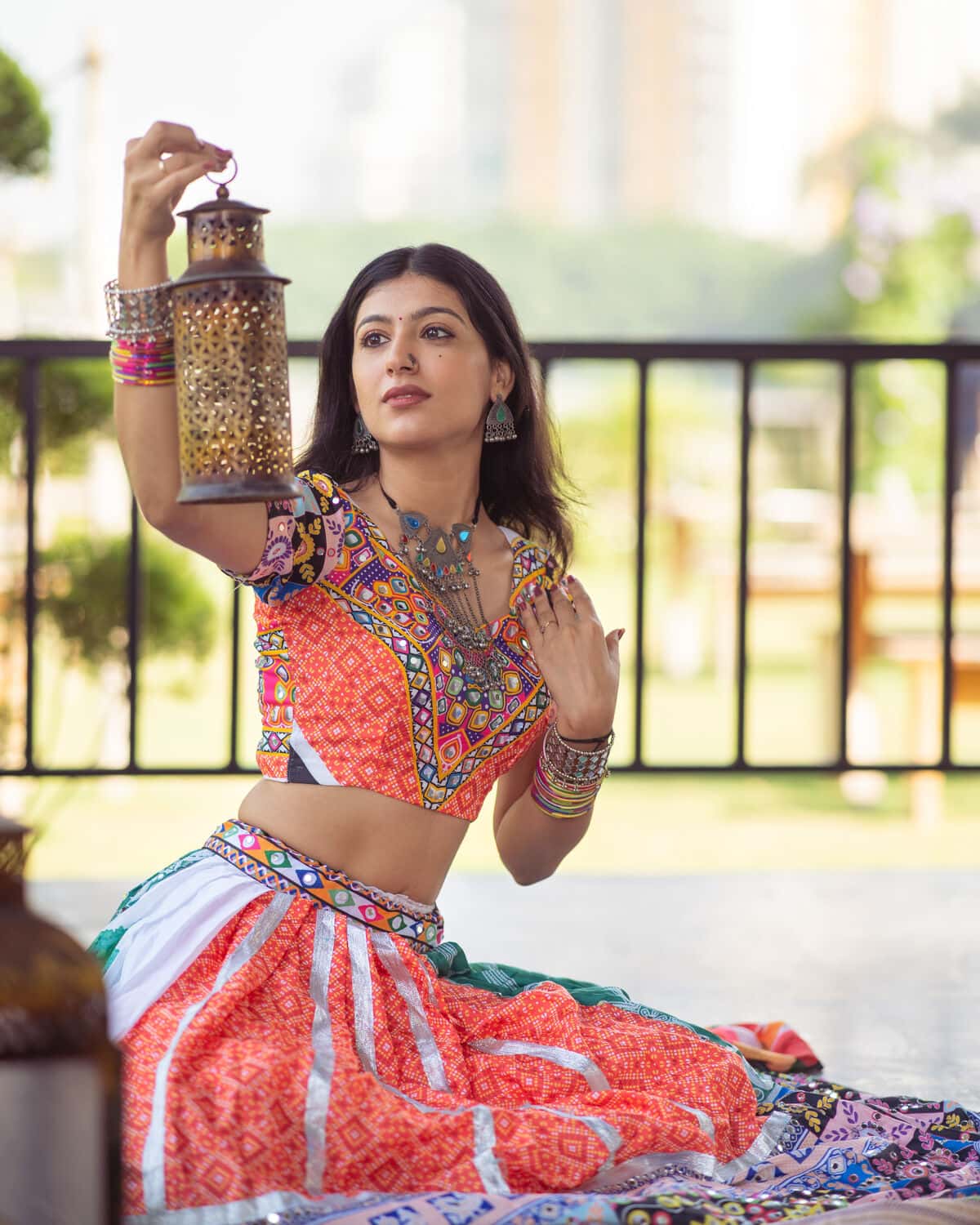 Sanya Ohri in a mirrorwork lehenga, holding a lantern